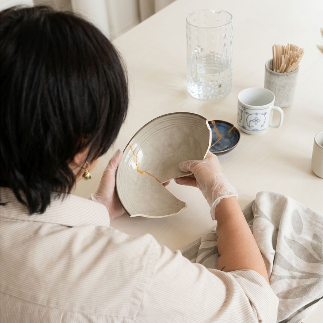 Handen repareren servies met goudlijm tijdens een creatieve Kintsugi workshop in Amersfoort