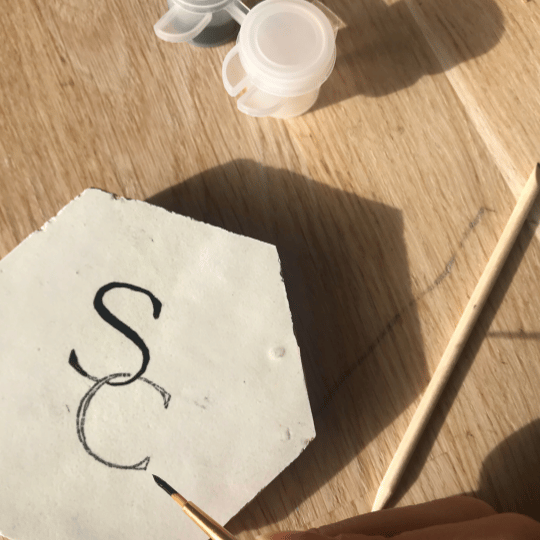 Het beschilderen van een handgemaakte zellige tegel tijdens een creatieve workshop in amersfoort.