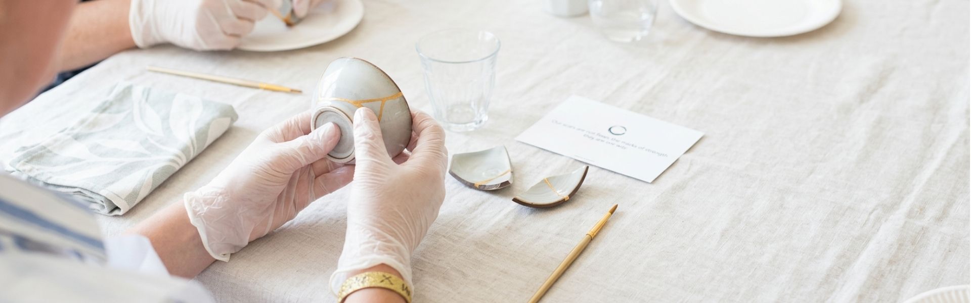 Handen repareren servies met goudlijm tijdens een creatieve Kintsugi workshop in Amersfoort