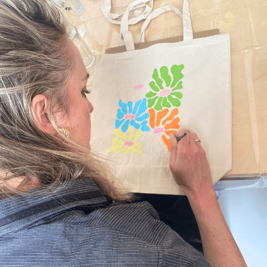 Textiel schilderen, een duurzaam katoenen totebag schilderen met textielverf tijdens een creatieve workshop.